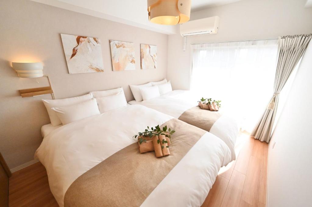 - une chambre avec 2 lits blancs avec des plantes dans l'établissement Shippo Mansion Room 402 - Vacation STAY 13861v, à Kichijōji