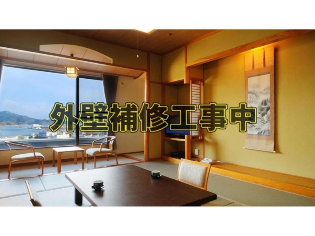 気仙沼市にあるSun Marine Kesennuma Hotel Kanyo - Vacation STAY 21044vのダイニングルーム(テーブル、椅子、窓付)