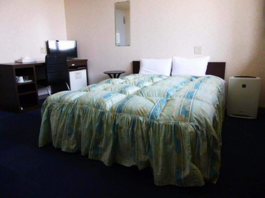 Hotel Wakow - Vacation STAY 22133v في يوناغو: سرير في غرفة الفندق بسرير كبير