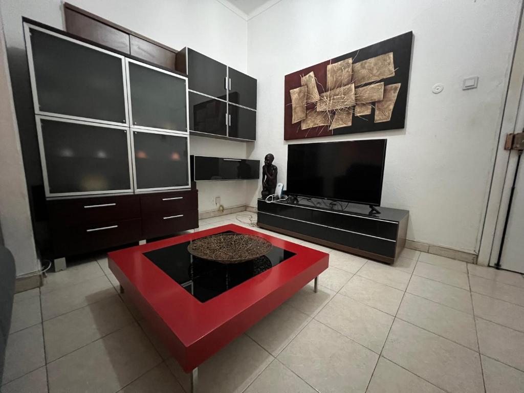 a living room with a red couch and a tv at África em Zona Comercial de Luanda in Luanda