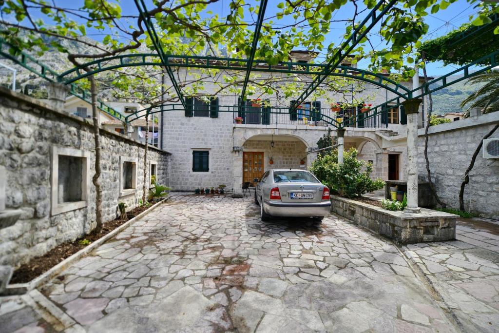 un coche aparcado en el patio de un edificio en Guesthouse Anita, en Kotor