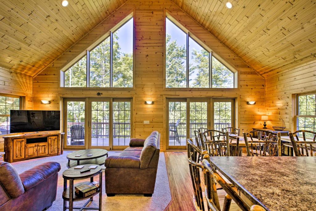 un soggiorno con mobili e finestre in una cabina di Lakefront Wisconsin Cabin with Boat Dock! a Birchwood