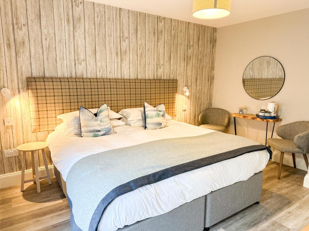 a bedroom with a large white bed with blue pillows at Beach House Hotel in Seahouses