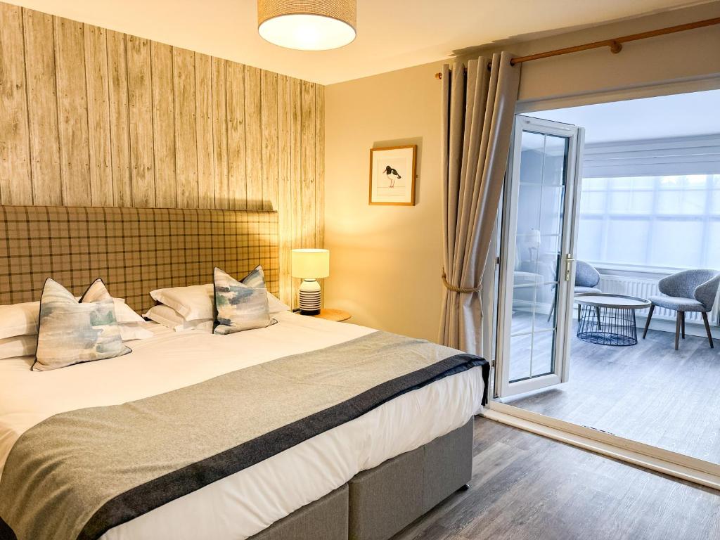 a hotel room with a bed and a balcony at Beach House Hotel in Seahouses