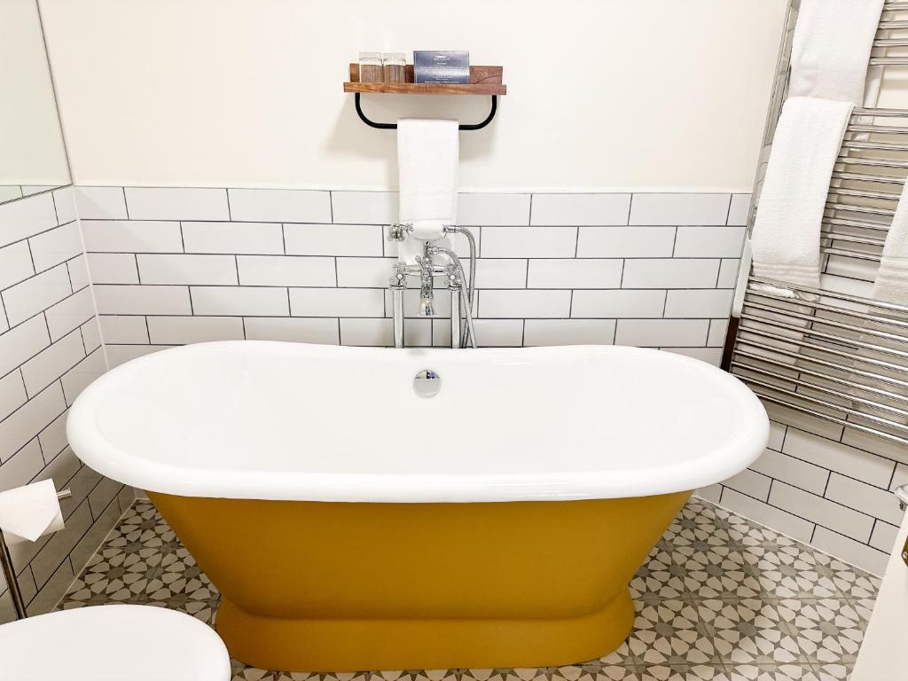 a bathroom with a yellow and white bath tub at Beach House Hotel in Seahouses