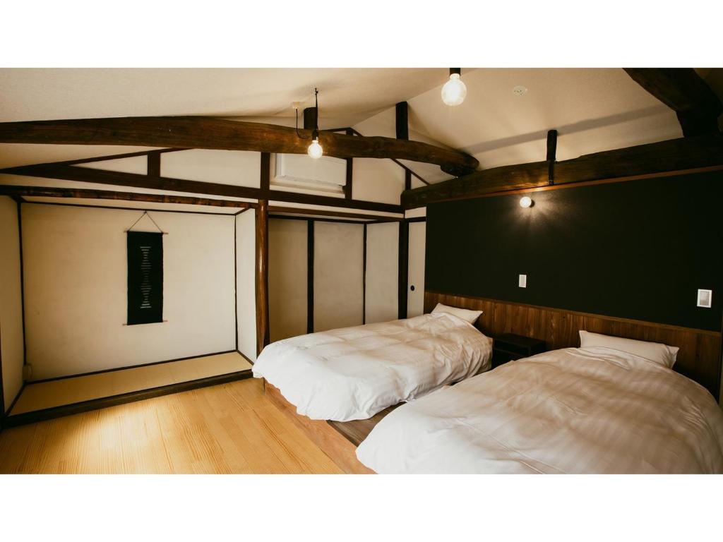 1 dormitorio con 2 camas en una habitación en Kominka Hotel kurasu - Vacation STAY 24275v, en Tatsuno