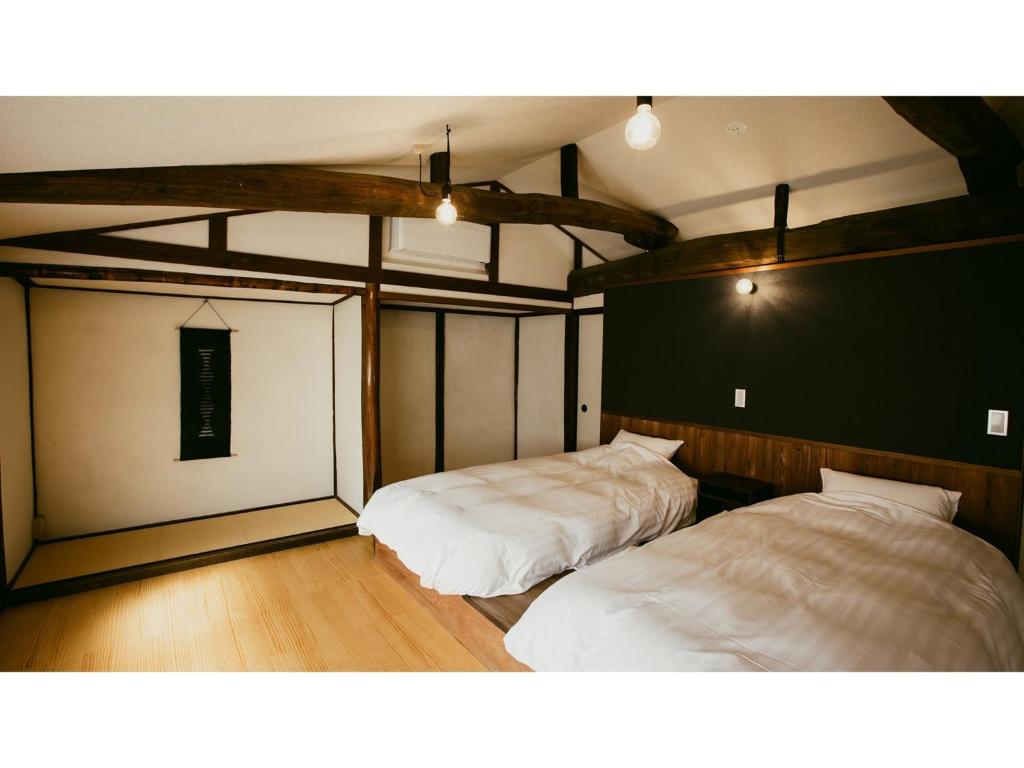 ein Schlafzimmer mit zwei Betten in einem Zimmer in der Unterkunft Kominka Hotel kurasu - Vacation STAY 24275v in Tatsuno