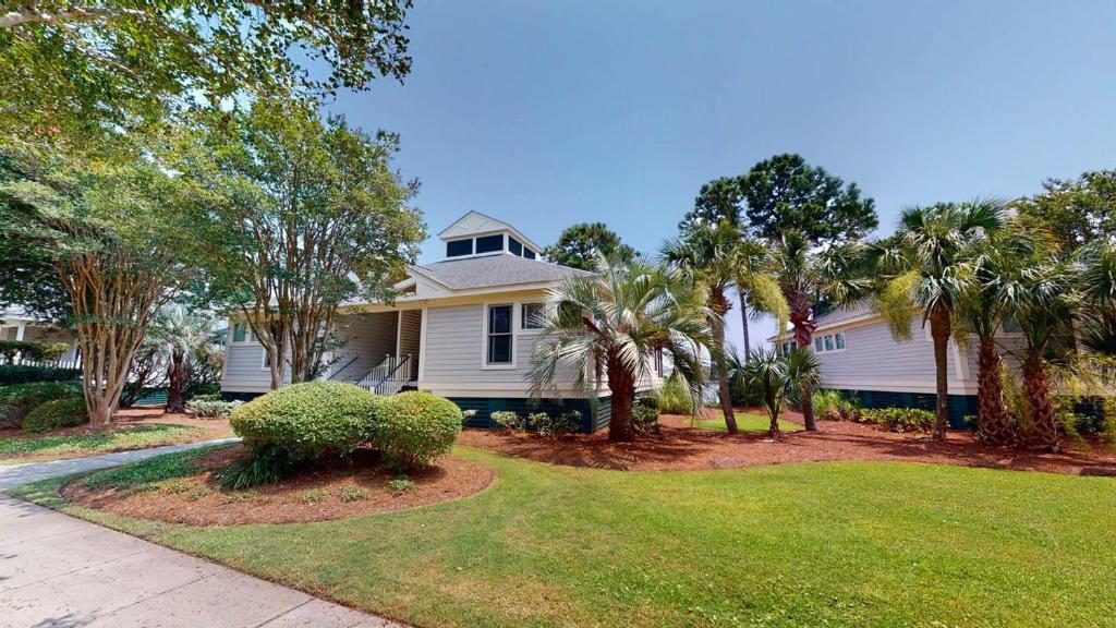 une maison blanche avec des palmiers dans une cour dans l'établissement Litchfield Beach Retreats 2BR Scenic Balcony Views, à Pawleys Island