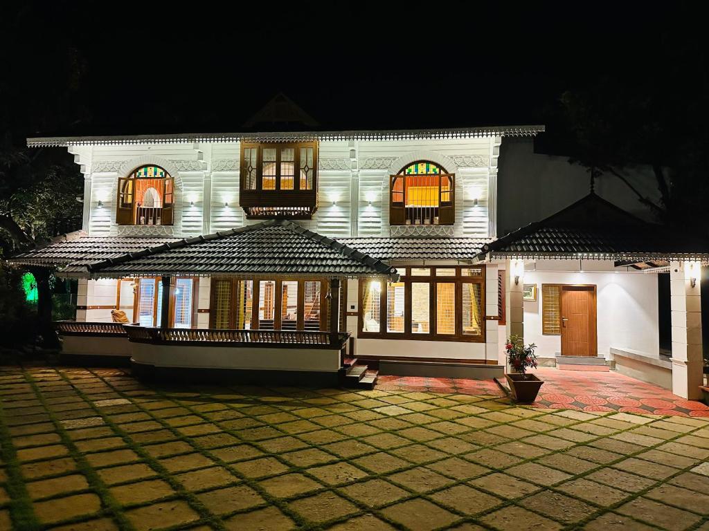 a large white building with windows at night at Farm Fort Resort By Luxdens Hotels in Kozhikode