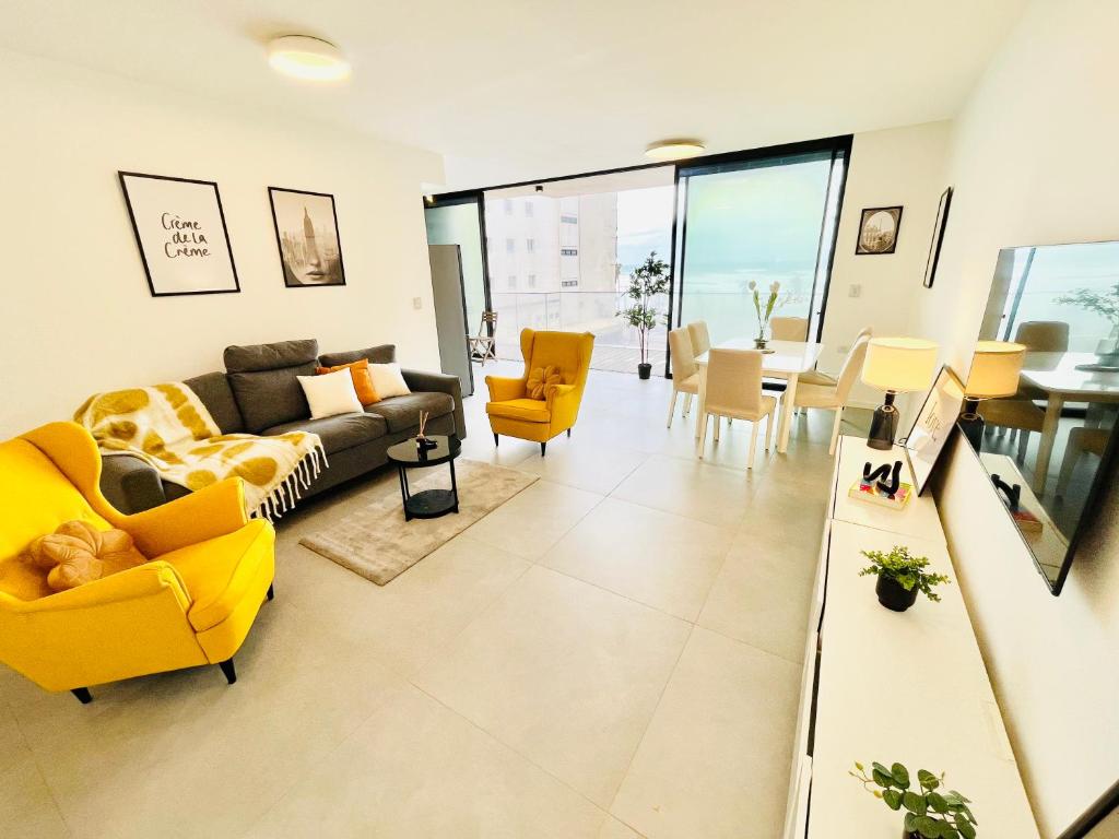 a living room with a yellow couch and chairs at Ayarkon CX - Elite Home Group in Tel Aviv