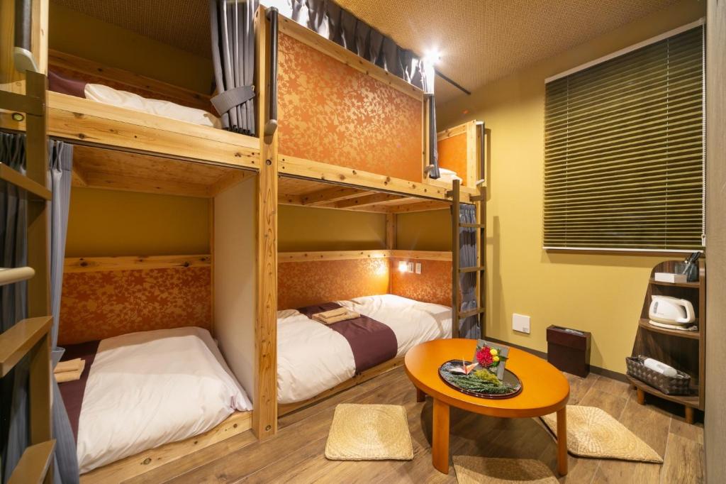 um quarto com 2 beliches e uma mesa em IKIDANE Cozy Hotel Haneda Airport - Vacation STAY 25834v em Tóquio