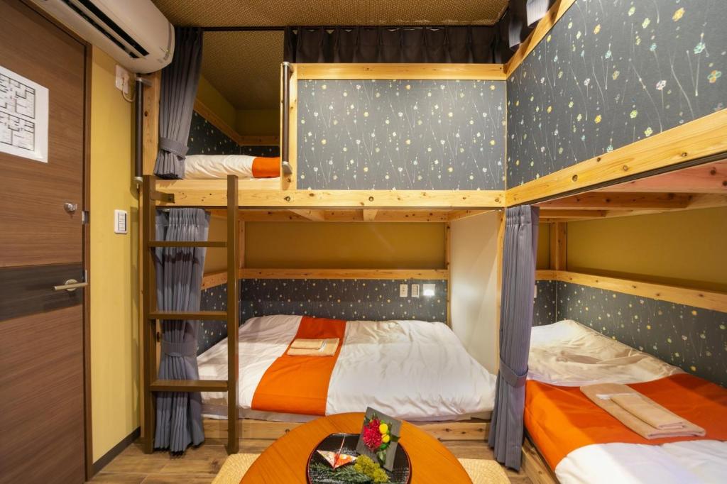 2 letti a castello in una camera con tavolo di IKIDANE Cozy Hotel Haneda Airport - Vacation STAY 25843v a Tokyo