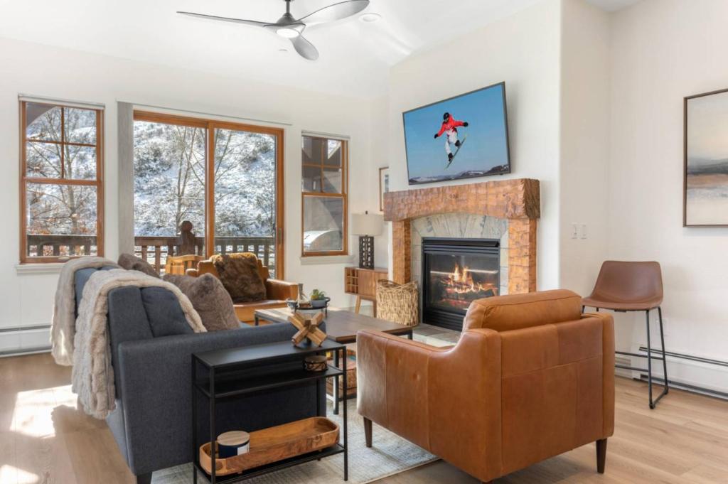 a living room with a couch and a fireplace at Lodge at Brookside 202 in Avon