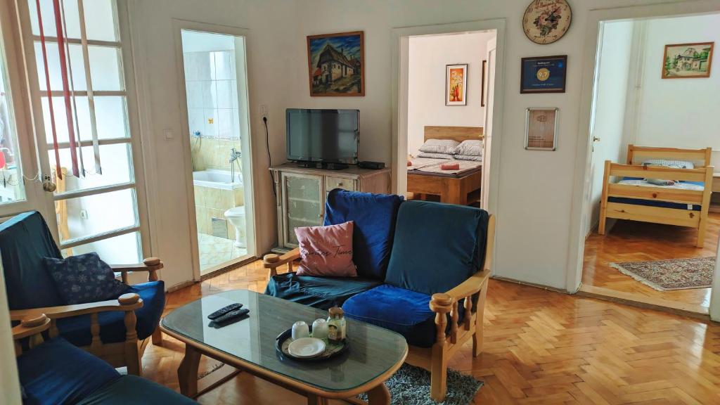 a living room with blue chairs and a table at Trosoban stan u Zenici in Zenica