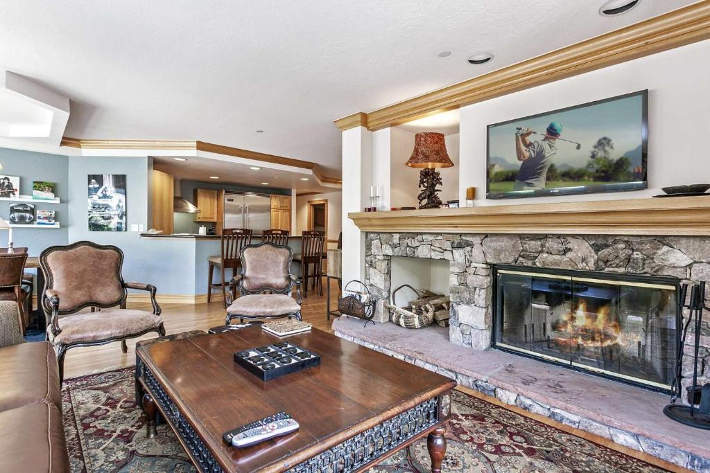 a living room with a fireplace and a table and chairs at Beaver Creek Lodge 512 in Beaver Creek