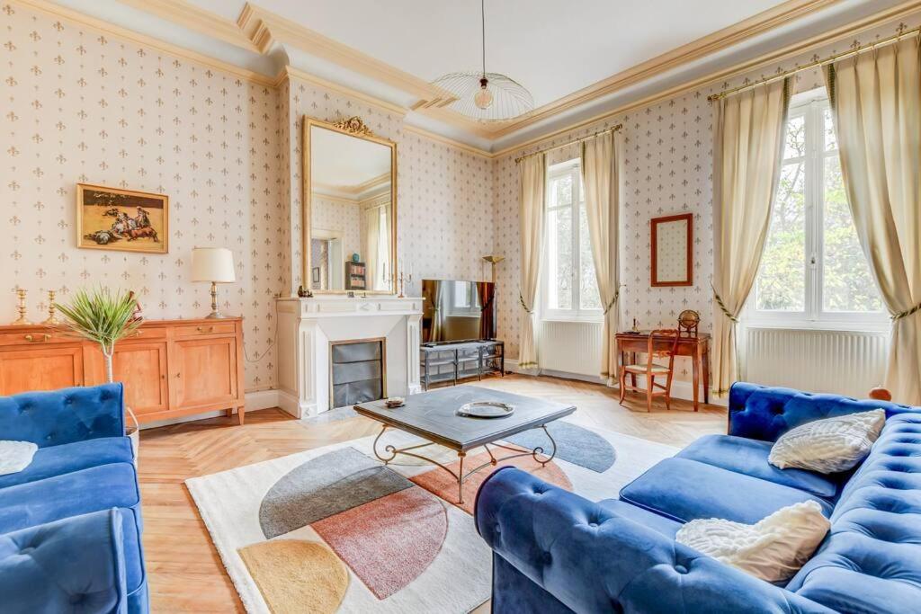 een woonkamer met blauwe meubels en een open haard bij Maison familiale - 11 personnes - Labège in Labège