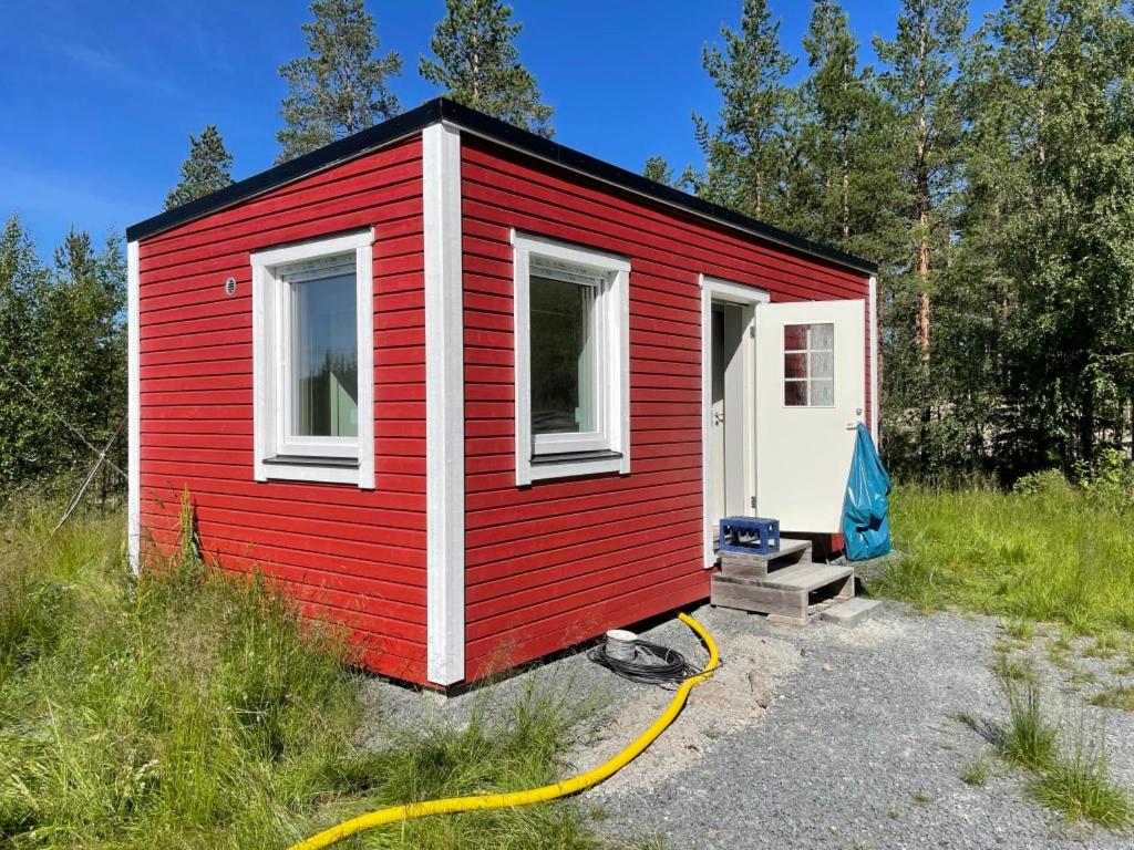 伊德烈的住宿－Fjällkåken，一间红色白色的小房子,有黄色的软管