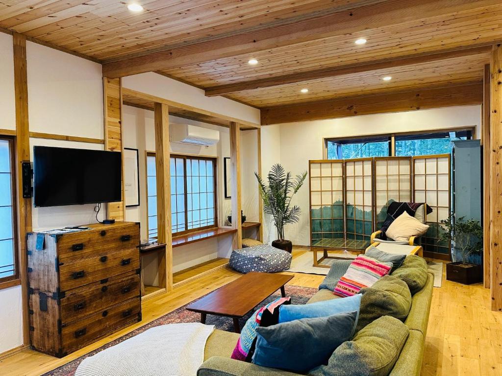 sala de estar con sofá y TV de pantalla plana en Hakuba Bliss Cottage - Vacation STAY 28524v, en Hakuba