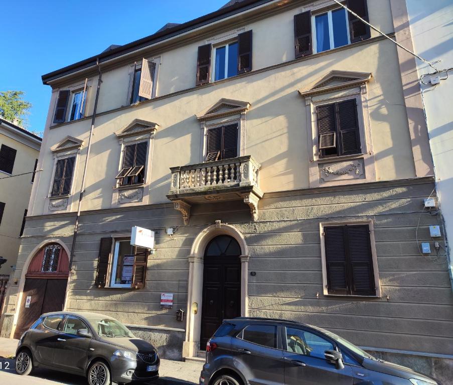 dos coches estacionados frente a un edificio en Appartamento Al Novecento Novi, en Novi Ligure