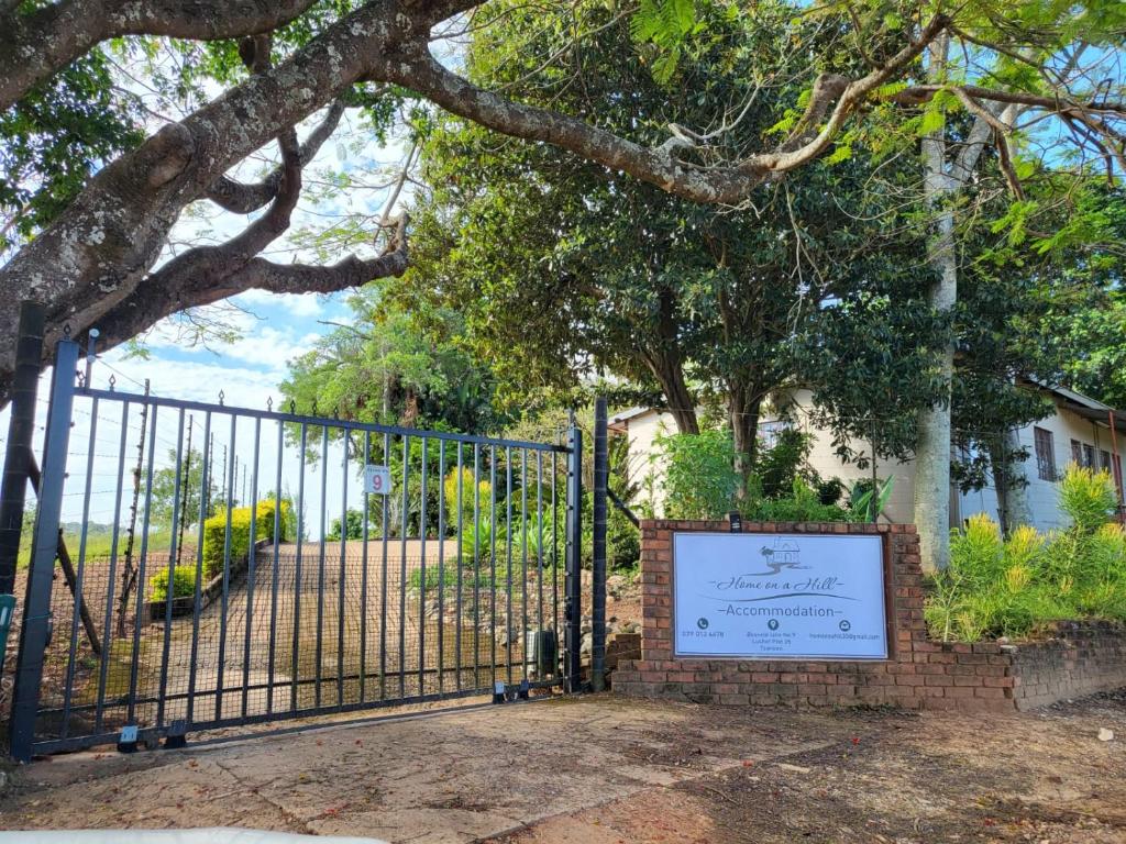 um portão com um sinal em frente a uma casa em Home on a Hill Accommodation em Tzaneen