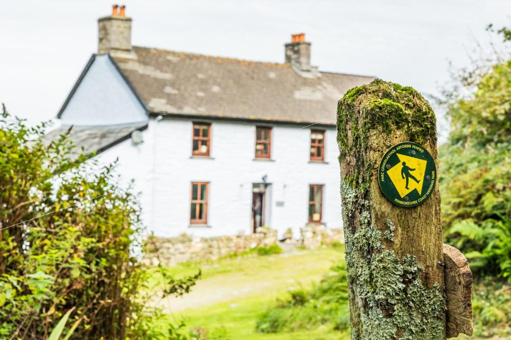 un cartel en un árbol delante de una casa en Aberfforest House, en Newport