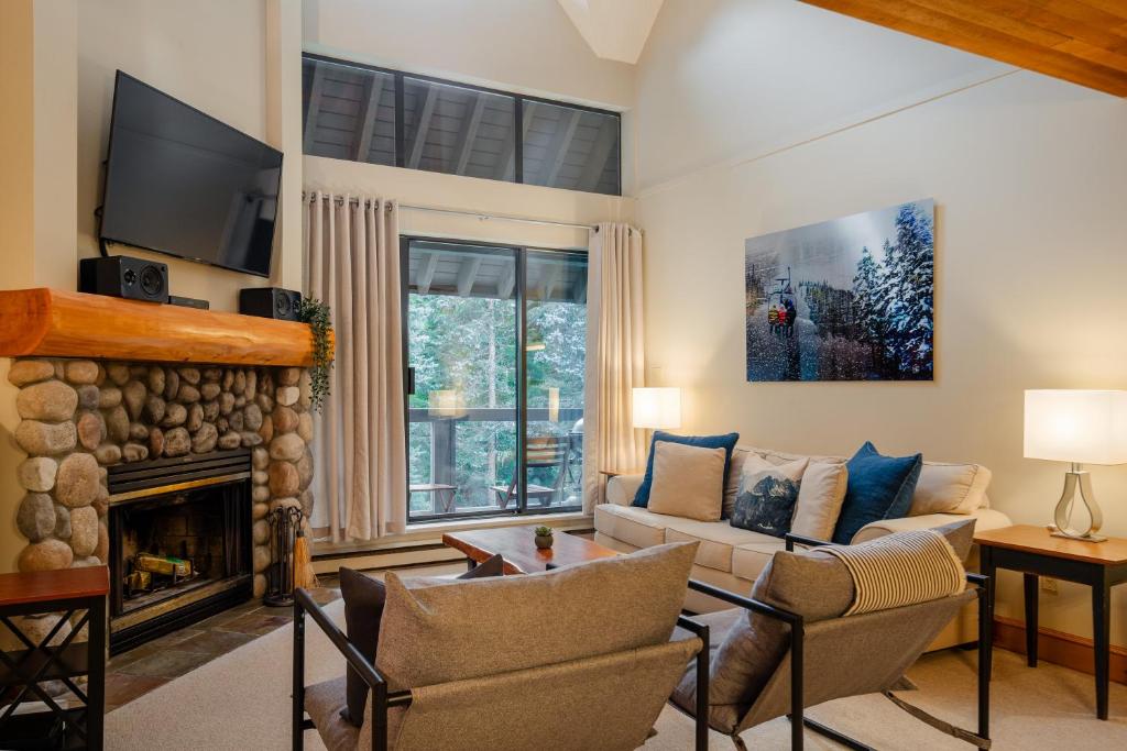 a living room with a couch and a fireplace at Spacious Benchlands Chalet by Harmony Whistler in Whistler