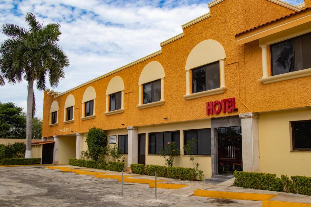 un hotel con una palmera delante en Hotel y Villas Costa del Sol en Mérida