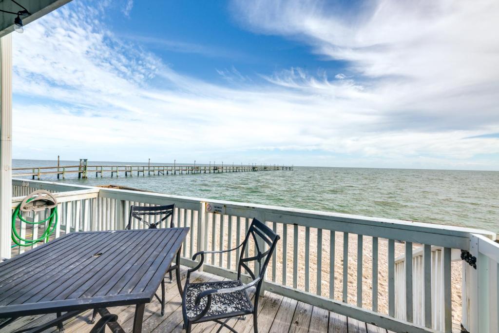 una mesa y sillas en una terraza con vistas al océano en Bayfront Texas Escape with Balcony and Pool Access!, en Rockport