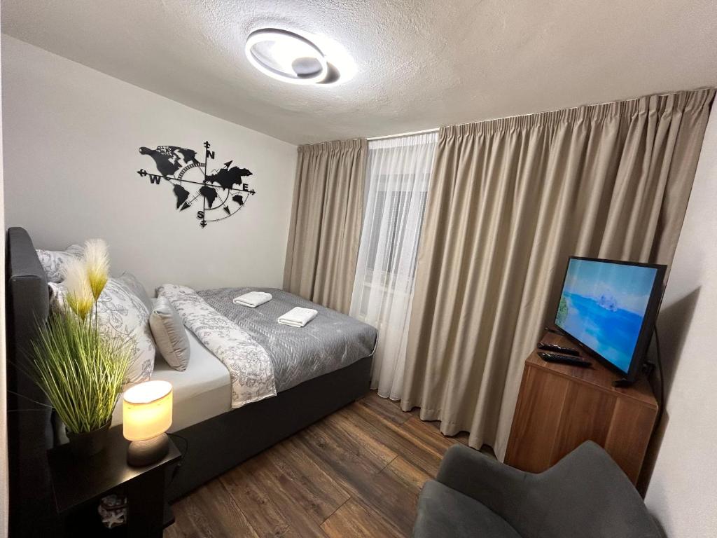 sypialnia z łóżkiem i telewizorem w obiekcie Komfortný apartmán s bazénom a súkromným parkoviskom-NONSTOP Check-in w Bańskiej Bystrzycy