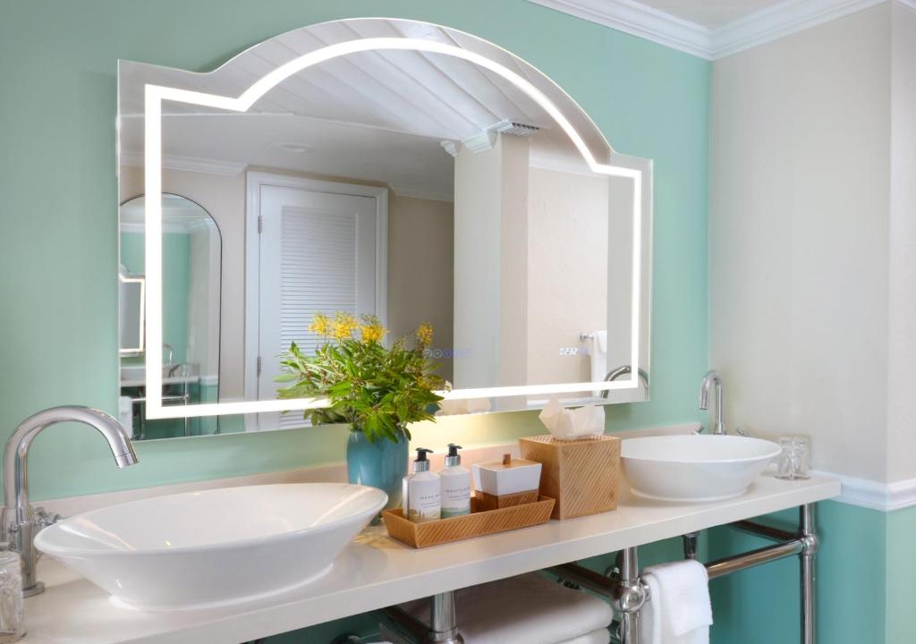 a bathroom with two sinks and a large mirror at Ocean Key Resort & Spa, a Noble House Resort in Key West