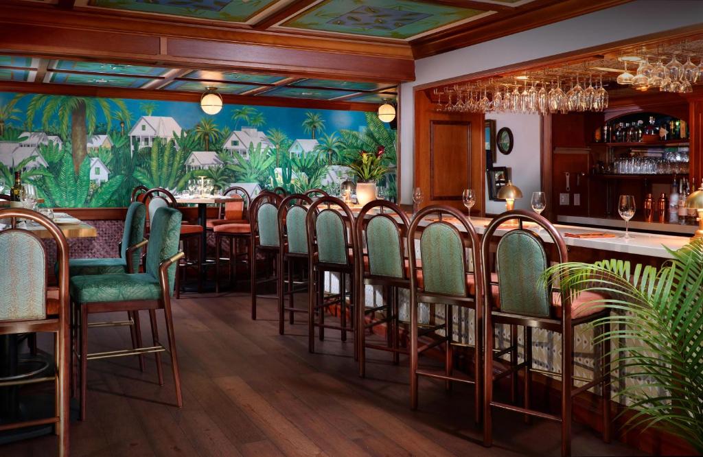 a dining room with chairs and a bar at Ocean Key Resort & Spa, a Noble House Resort in Key West