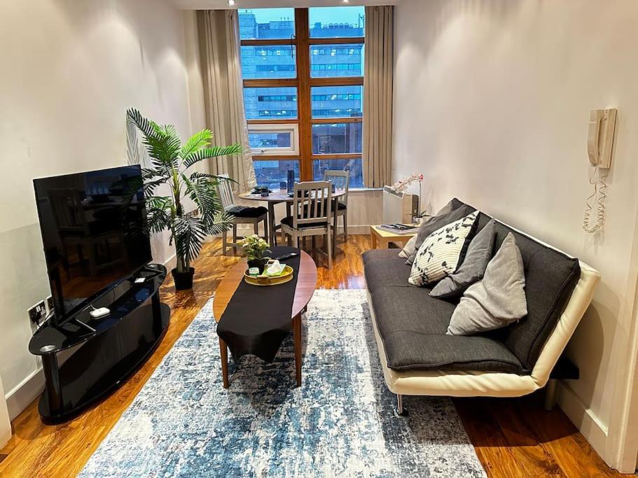a living room with a couch and a table at Luxury Two Bedroom En-Suité Apartment in Manchester