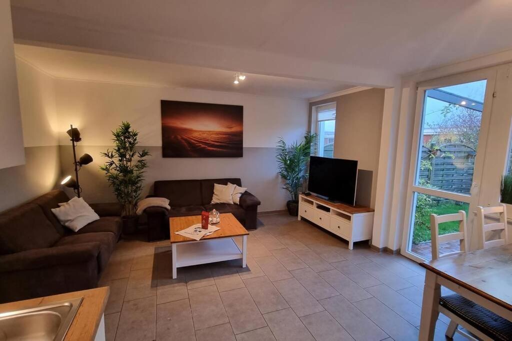 a living room with a couch and a tv at Ferienhaus Klippenbarsch in Dornum