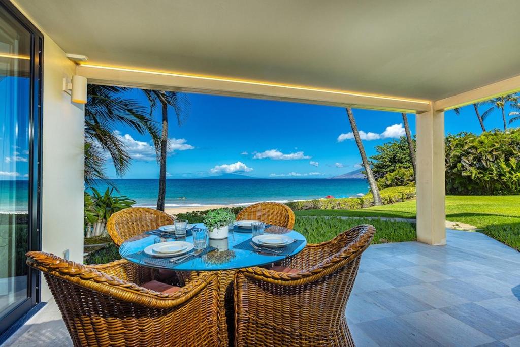 a table on a patio with a view of the ocean at Polo Beach Club 106 condo in Wailea