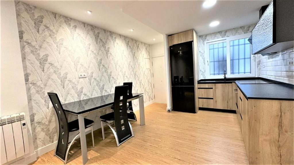 a kitchen with a table and chairs in a room at Bonito Apartamento en Zamakola in Bilbao