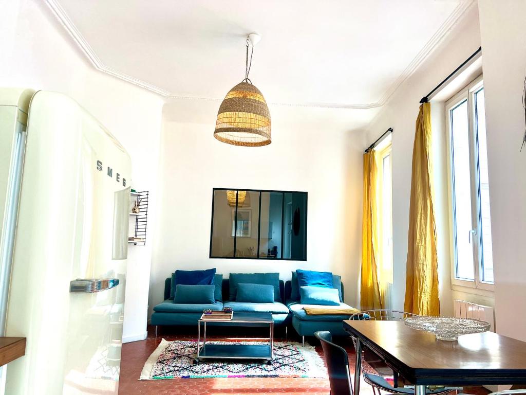 un salon avec un canapé bleu et une table dans l'établissement Casa Mandulina - Plein cœur du Quartier Préfecture, à Marseille