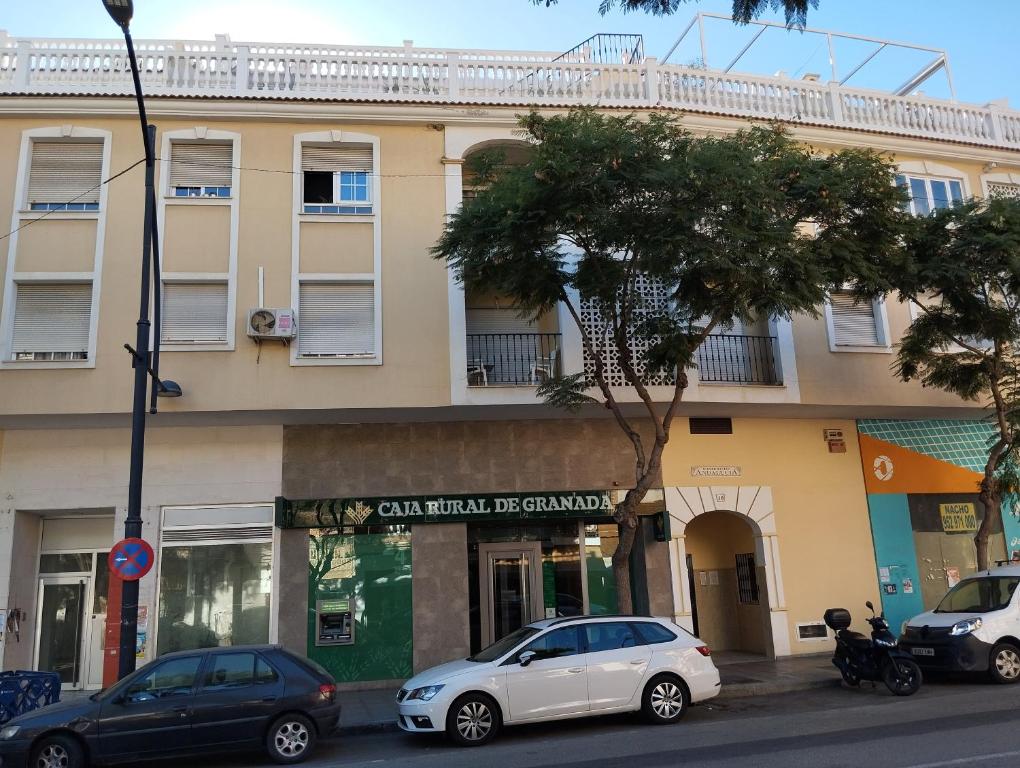 a building with cars parked in front of it at Piso encantador Mediterráneo in Rincón de la Victoria