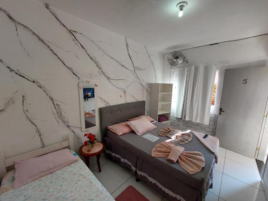 een slaapkamer met 2 bedden en een marmeren muur bij Guest House Palmeiras in Cabo Frio