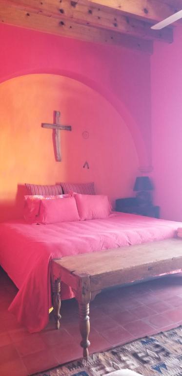 1 dormitorio con 1 cama con una cruz en la pared en Posada de la Cruz, en Querétaro