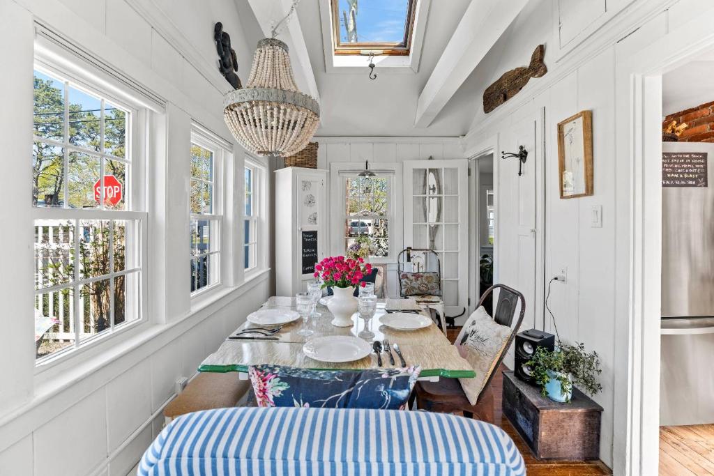 a dining room with a table and chairs and windows at 227 Winter St, Hyannis in Barnstable