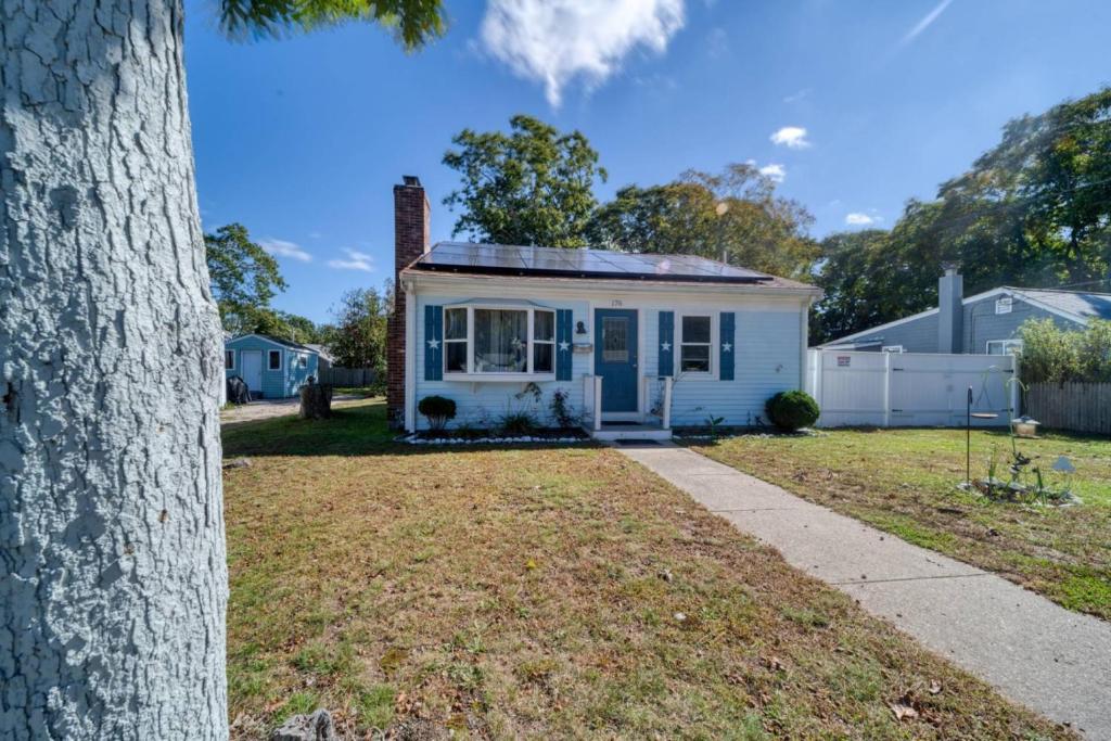 una pequeña casa blanca en un patio con un árbol en Comfortable 2 Bedroom Gateway nearby Downtown, en Barnstable