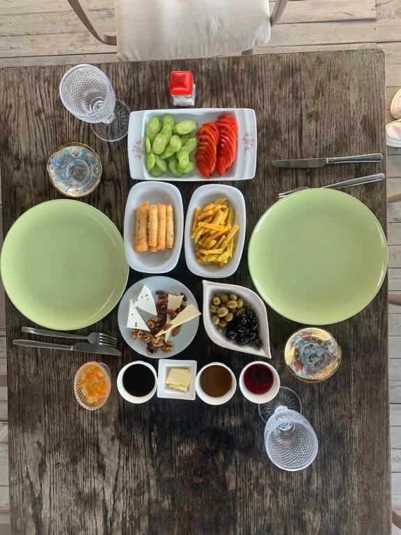 une table avec des assiettes et des bols de nourriture dans l'établissement Mozaik Pansiyon, à Kaş