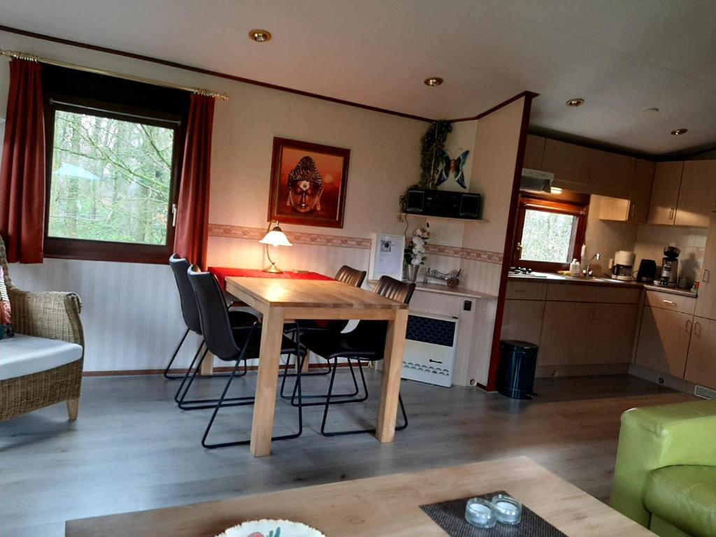 sala de estar con mesa de madera y sillas en Boszicht-Winterswijk en Winterswijk