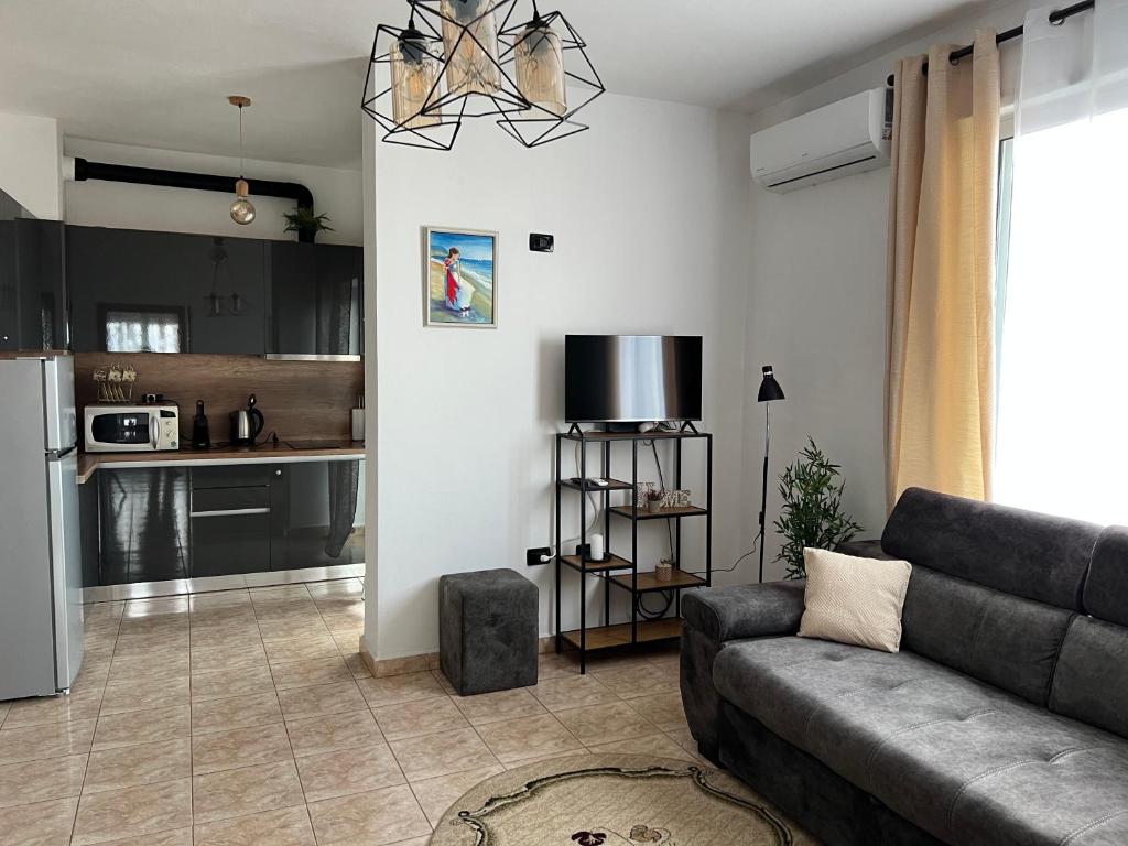 een woonkamer met een bank en een keuken bij Sergio Apartment in Durrës