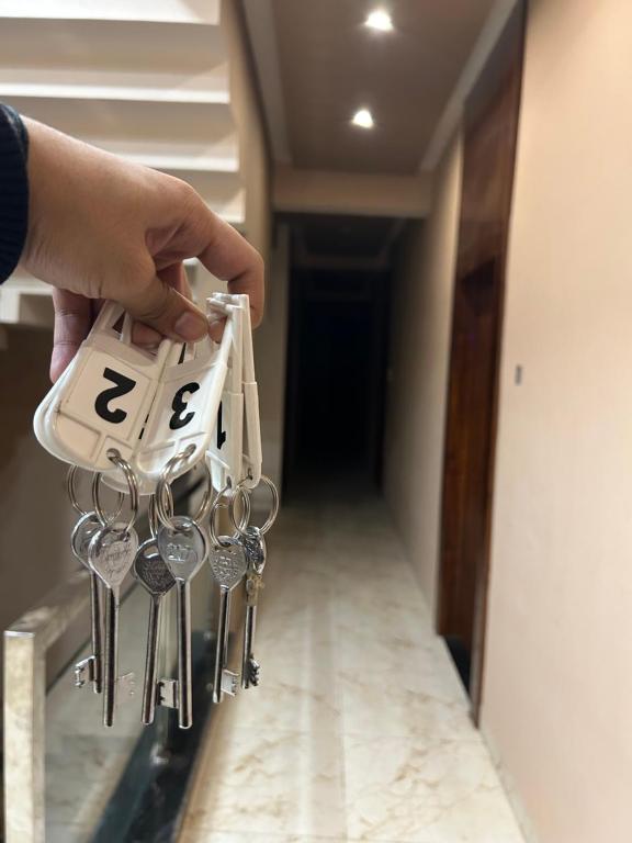 una persona che tiene un mazzo di chiavi in un corridoio di Hotel New agrawal pudi bhandar a Hoshangābād
