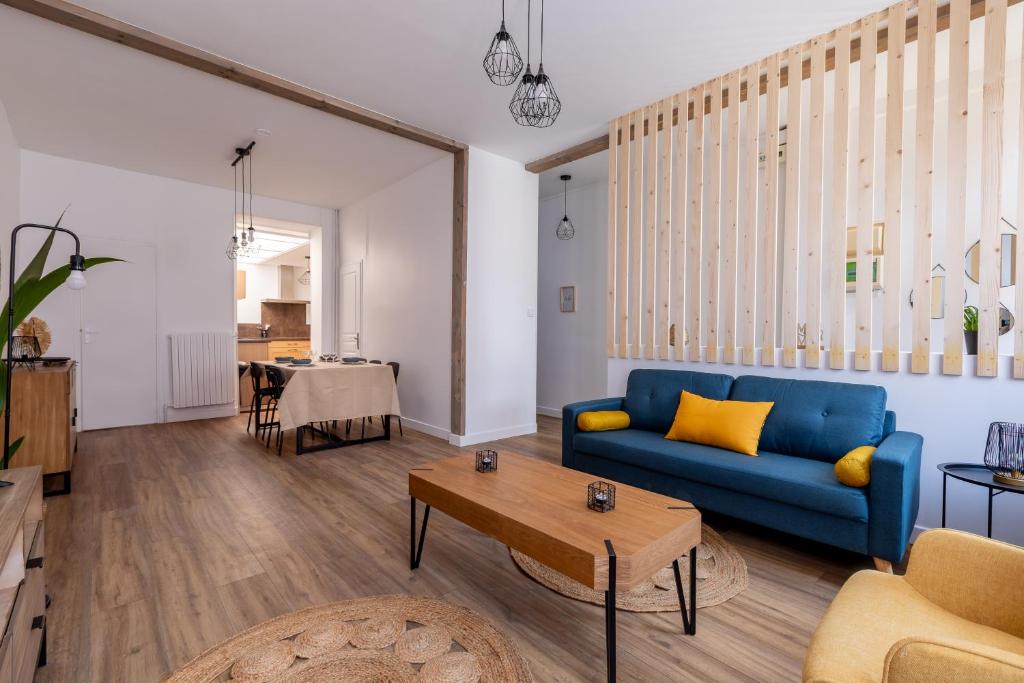 - un salon avec un canapé bleu et une table dans l'établissement La Saint-Quentinoise chambre privée amande, à Saint-Quentin