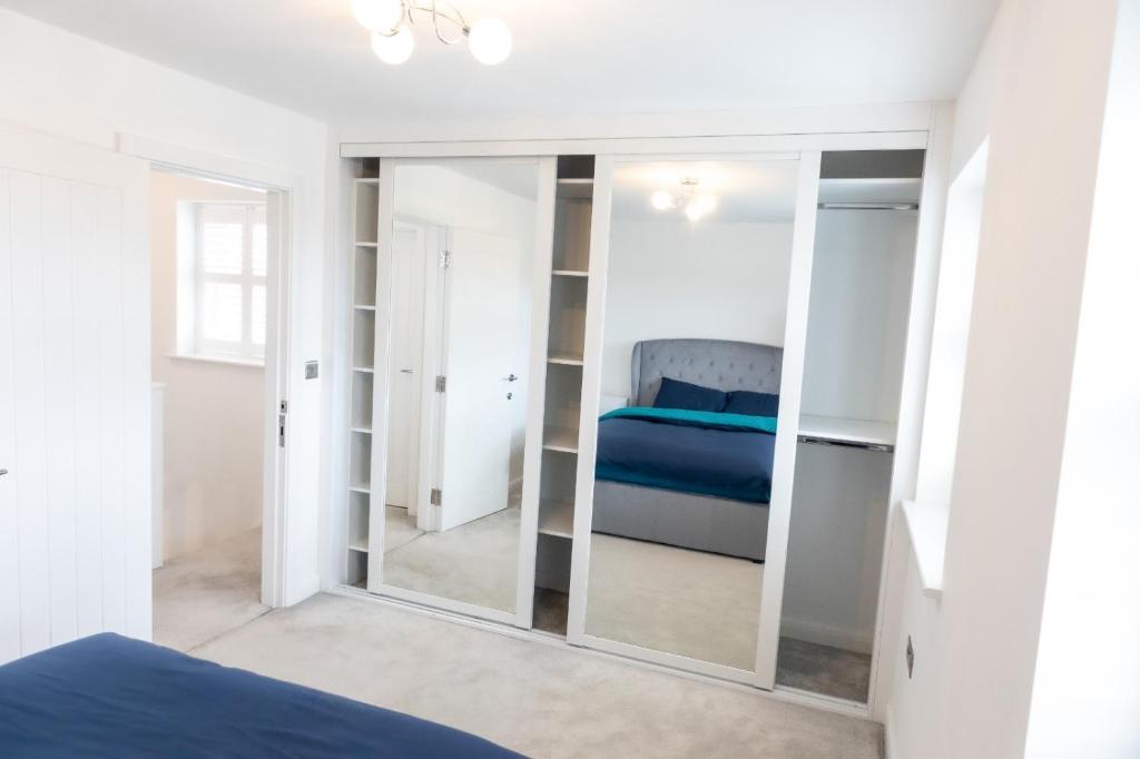 a bedroom with a mirror and a bed at Private room in a new build in Heanor