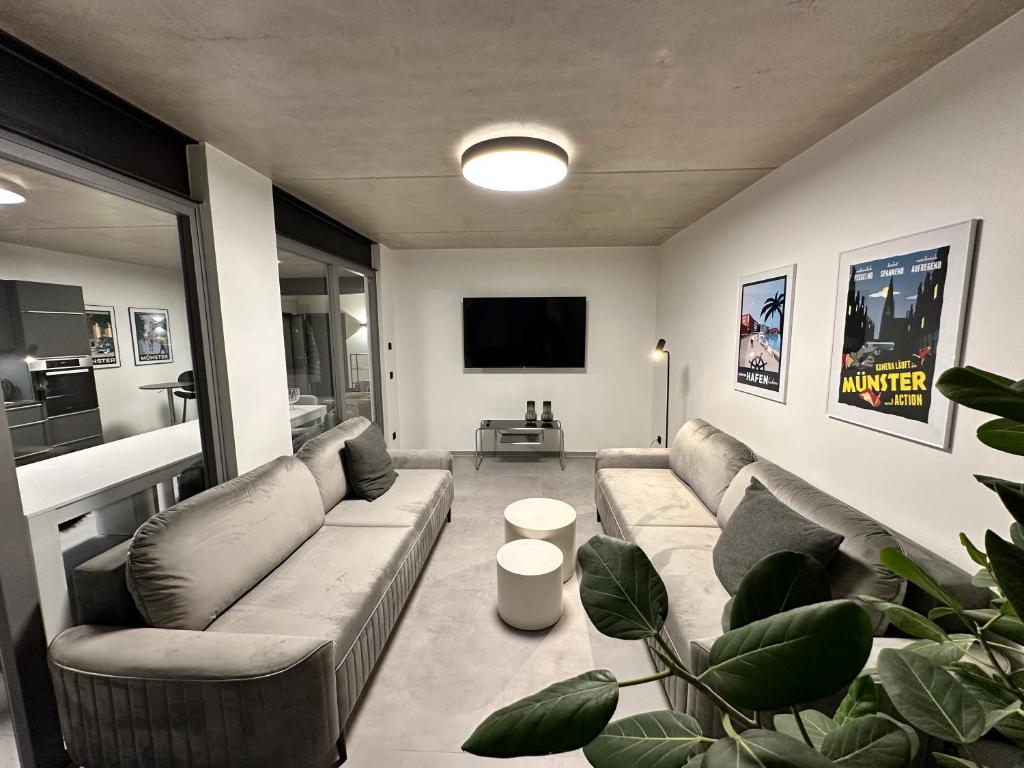 a living room with couches and a flat screen tv at Luxuriöses Apartment direkt am Kanal 125 m² - youpartments in Münster