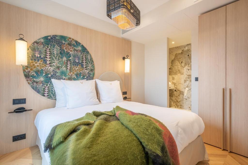 - une chambre dotée d'un lit blanc avec une couverture verte dans l'établissement Yuna Saint-Germain-des-Prés - Serviced Apartments, à Paris