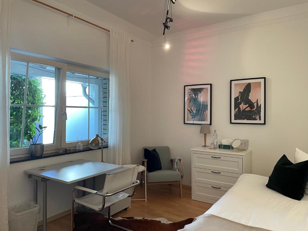 1 dormitorio con cama, escritorio y ventana en Privates Zimmer in einem gepflegten Bungalow, en Neuss